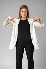 Confident Young Businesswoman Presenting With Hand Gesture in Studio Setting