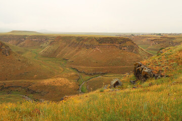 The Tsaghkotsadzor valley, gorge, canyon of the Alaca Cay river with man made caves next to the...