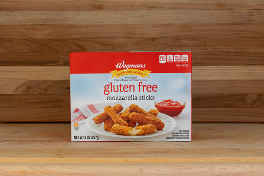 package of wegmans brand gluten free frozen mozzarrella sticks for the gluten free diet on a rustic wood background with copy space