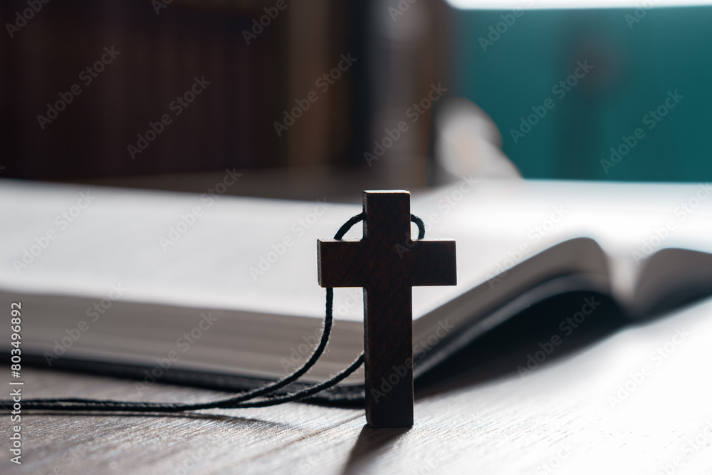 Poster wooden cross necklace next to open bible, christian concept, religious symbol - Posters