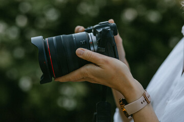 Professional camera in woman's hands, closeup