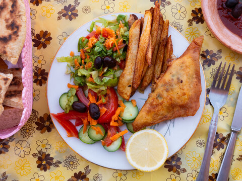 Appetizing tunisian dish pie brik served with vegetable salad on platter
