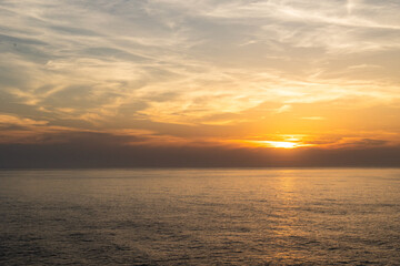 Obraz premium Landscape photo of dramatic, steep orange cliffs by the atlantic at sunset. Shot in Farol fo Cabo de Sao Vincente near Sagres, Portugal.