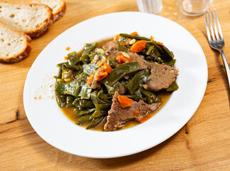 Stewed beef and side dish - braised of string beans, carrots, onions. Dish is complemented with...