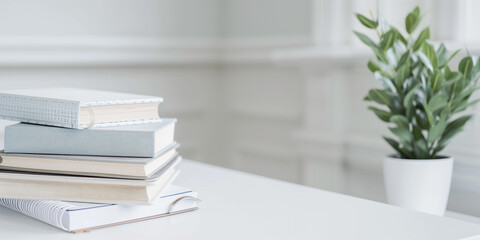 A simple yet impactful photo of stack of books and planners positioned neatly on a white elegant teacher's table, symbolizing the essence of back to school readiness and the import