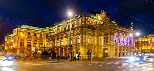 Scenic view of busy night central avenue of Vienna and impressive illuminated building of famous State Opera in winter, Austria.