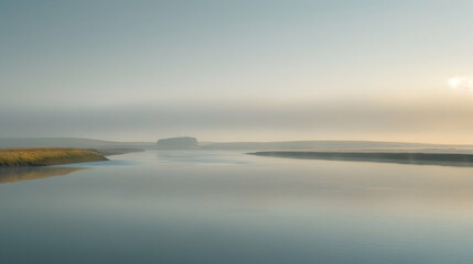 Misty morning at a river estuary, with fog hovering over calm waters and distant hills partially visible