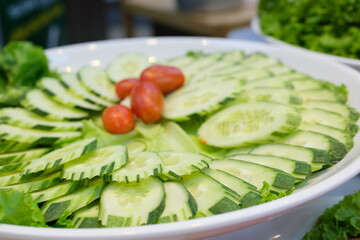 Abstract background of green cucumber slices on a white plate. View from above.