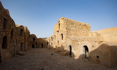 Ruins of ancient abandoned Berber granary structures in Ksar Daghar in Tunisia, standing as...
