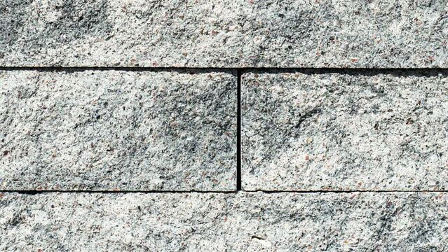 Grey modern coble stone video background. Close up top view on monotone gray brick stone. Sidewalk or pavement. Top view, copy space video banner.