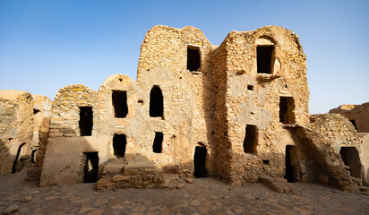 Ruins of ancient abandoned Berber granary structures in Ksar Daghar in Tunisia, standing as...
