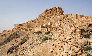 Ancient stone houses and on the mountain slopes in the Guermassa region. South Tunisia. Tatouine...