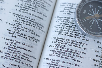 Open holy bible book with compass. Close-up. Christian biblical concept of God's guidance, instruction, teaching, and counsel.