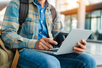 Naklejka premium Man using a laptop and smartphone for booking hotel online. Tour reservation, Booking online concept