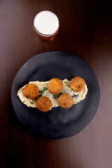 fried fish cake appetizer salmon cod with half pint of craft beer in pub top view