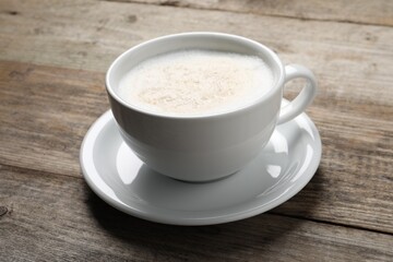 Aromatic coffee in cup on wooden table