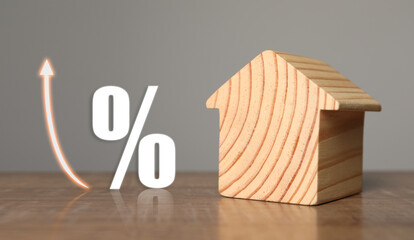 Mortgage rate. Wooden model of house, arrow and percent sign on table, banner design