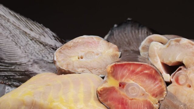 Fresh fillet sturgeon fish on desk close-up. Roast healthy food concept. Chef preparing to cook sturgeon, hake, cod fish steak pieces fillet with spice on grill. Healthy diet food