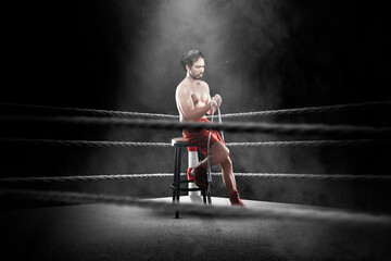 Portrait of a boxing man sitting and wrapping his hand with tape