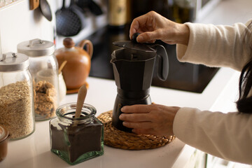 Woman making coffee in an italian coffee maker