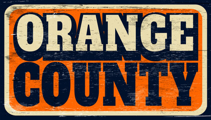 Aged and worn retro Orange County sign on wood
