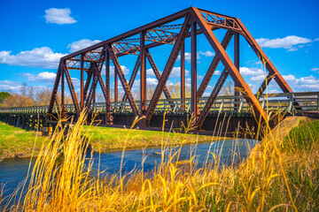 Old rustic railroad bridge over Big Sioux River walking trail near Sertoma Park in Sioux Falls, South Dakota,on a sunny spring afternoon