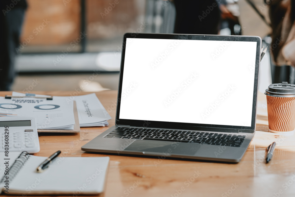 Poster organized workspace featuring an open laptop with a blank screen, a coffee cup, and documents with g