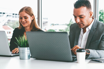 Businessman executive is in meeting discussion with a businesswoman worker in modern workplace...