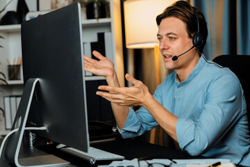 Call center consulting with customers on headphones on monitor in business paragraph with typing on...