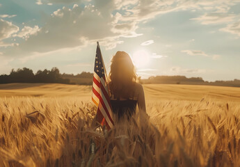 A woman holding an American flag stands in the middle of a wheat field - Powered by Adobe