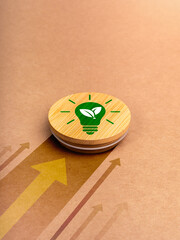 Green power energy icon with lightbulb and leaf symbol on round wood badge moving fast with heading arrows on brown recycled paper background. Eco-Minded entrepreneurs running green business concept.