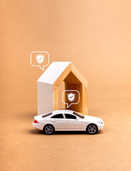 Home and car insurance concept. Shield icon in speech bubbles on white toy car and modern house...
