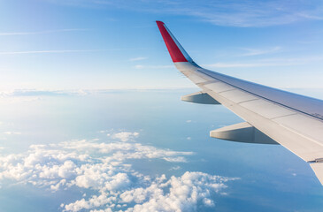 View from the airplane window at a beautiful cloudy sky and the airplane wing