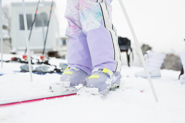 雪山でスキーをする小学生の女の子の足元