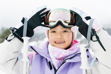 雪山でスキーをする小学生の女の子