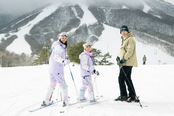 雪山でスキーを楽しむ家族,父母娘