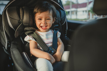 happy toddler girl sitting in car seat, safety baby chair travelling