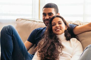 Romantic stock photo of young couple on sofa at home