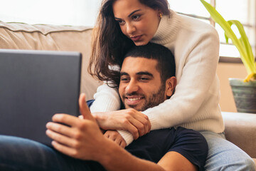 Young couple enjoying a movie on laptop at home