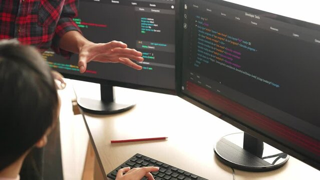 Slow motion back end or software developer manager supervising his team on new application program development on debugging and solving complex code algorithms on monitor. Burgeoning