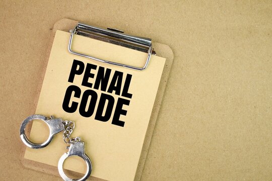 iron handcuffs and a book board with the word Penal code. Criminal law concept. concept of serious offense