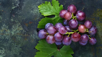 Bunch of ripe red grapes with green leaves on rustic background - obrazy, fototapety, plakaty