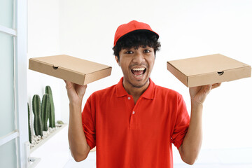 Delivery man in red uniform deliver two boxes of pizza. Fast food delivery concept.