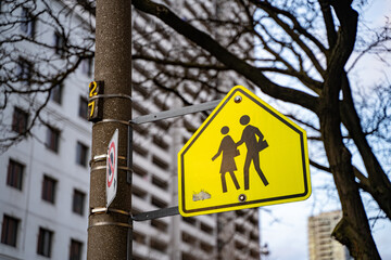 Yellow warning road sign for a school zone.