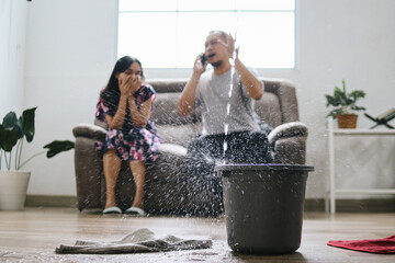 Water drips into buckets in living room as frustrated couple calling for insurance company 