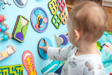 Baby playing with different entertaining elements on the game board