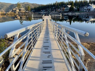 lake fishing walking pier dock over calm smooth water reflections and beauty in nature, mountains and forest