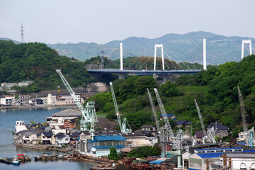 造船所のクレーン群と因島大橋。