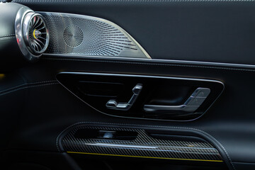 close-up of the side door buttons: window adjustment buttons, door lock. modern car interior:...