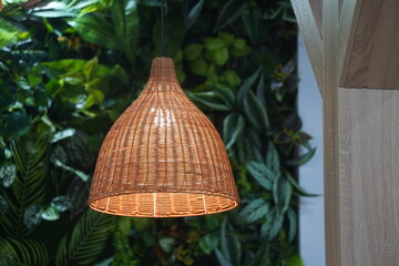 A braided lampshade with an electric light bulb.